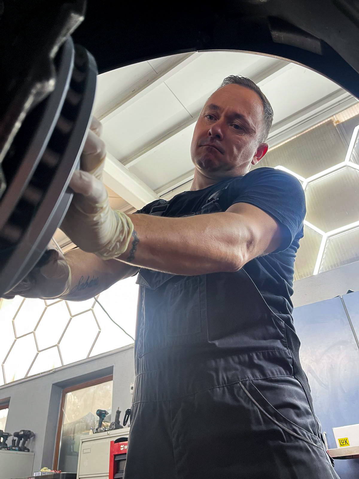 Kfz-Meister Oleg Klaus bei der Bremsenreparatur in der Werkstatt Würzburg